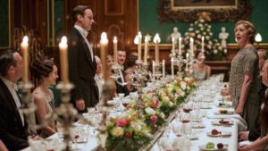 Man and woman standing at ornate dining table. Screenshot from Downton Abbey.