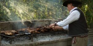 Man making barbeque on a stone charcoal grill.
